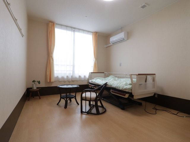 居室の明るい一角 居室 広々として明るい居室です。落ち着いた色合いで統一されており、快適な生活空間が提供されています。