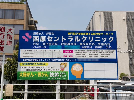 看板の前を行く人