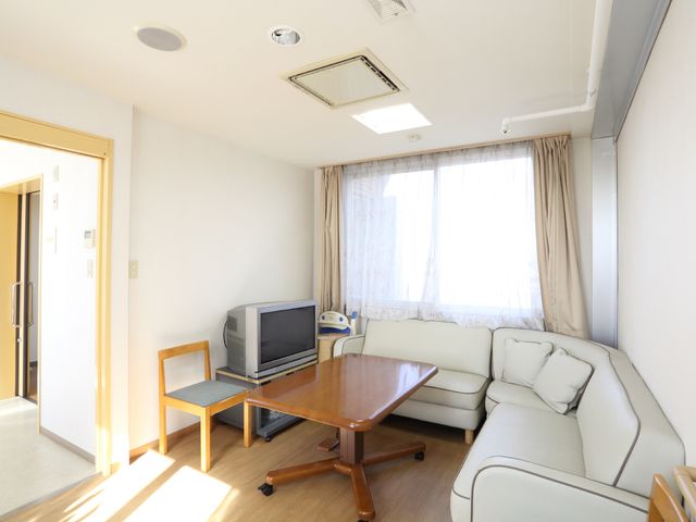 居室の明るい空間 ラウンジ ゆとりのある居室です。日当たりの良い窓と清潔感のある家具が配置されており、くつろぎの時間を演出します。