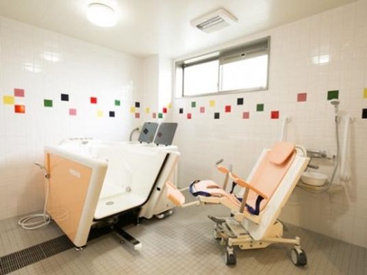 介護浴槽が設置されていて機械浴が可能である。浴室の壁にはカラフルなタイルが張られ、明るい雰囲気である。