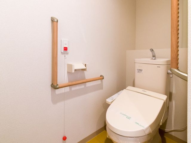 バリアフリー設計のトイレ トイレ 安全に配慮した設計のトイレで、手すりと緊急呼出しボタンを設置してあります。ゆったりと利用できる広さも確保されています。
