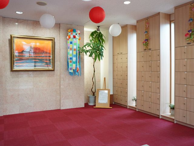 赤いカーペットのエントランス 玄関 和洋の要素が融合した温かみのあるエントランスです。居心地の良い環境で働けます。