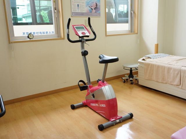 運動機器とベッドの部屋 リハビリルーム 床が清潔で明るい訓練スペースです。安心して身体を動かせる環境が整っています。