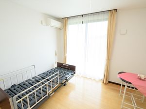 明るい居室のベッドと窓