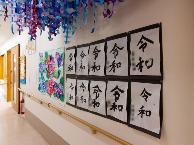 壁掛けの書道作品 掲示物 廊下に飾られた書道作品が、日々の暮らしに潤いを与えています。ご入居者の作品かもしれませんね。