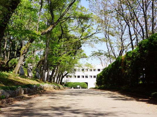 門から施設までの緩やかな坂の両側には、木がたくさん立ち並んでいる。坂の途中には、モアイ像が置かれている。