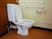 正面に洋式の便器が設置されている。そのそばにはトイレットペーパーがあり、右側には緊急呼び出し装置が付いている。