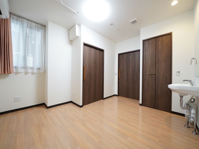 清潔な居室の様子 居室 広々とした居室は落ち着いた色合いで、洗面台も完備され、快適な生活空間が提供されています。