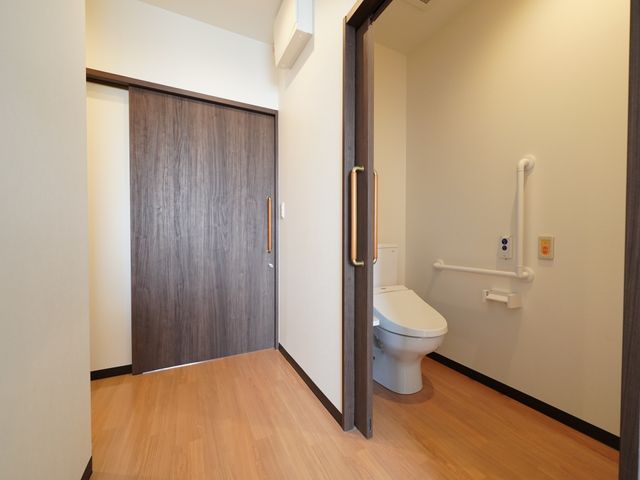 バリアフリーの個室トイレ 居室 手すり付きの清潔感あるトイレが整っており、安全かつ快適にお使いいただけます。明るい個室で、プライバシーもしっかりと守られています。