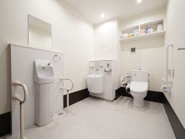 バリアフリー設計のトイレ 共有トイレ 安全に配慮された手すり付きトイレです。清潔感があり、安心してお使いいただける環境を整えています。