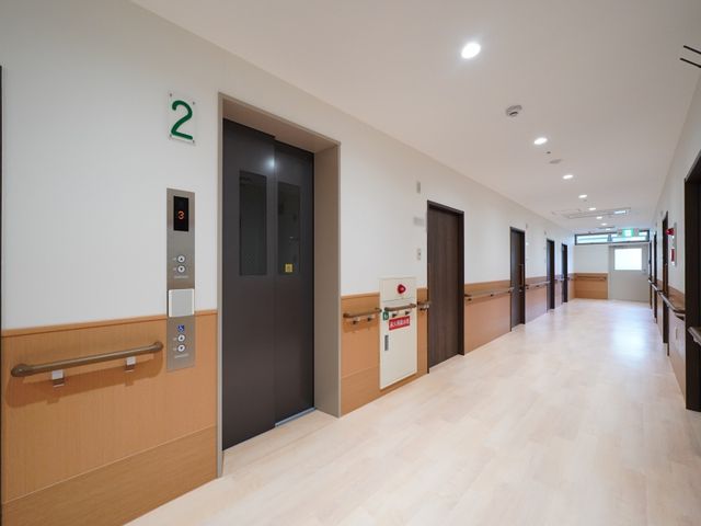 広々とした明るい廊下 廊下 ゆとりあるスペースで設計された廊下は、明るく開放的な雰囲気を醸し出しています。手すりも備えられ、安全に移動できる環境になっています。