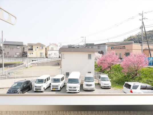 春景色と駐車場の外観