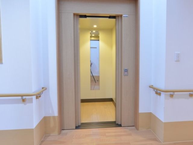 手すり付きのエレベーター入口 エレベーター 手すりが設置された安全なエレベーター前です。車椅子の方も安心して利用可能で、移動の利便性を重視しています。