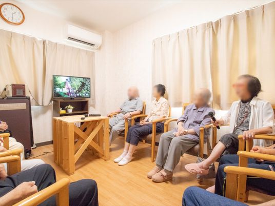 リビングでテレビを見る人々