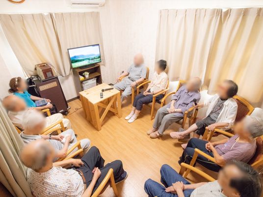 居室でテレビを見る人々