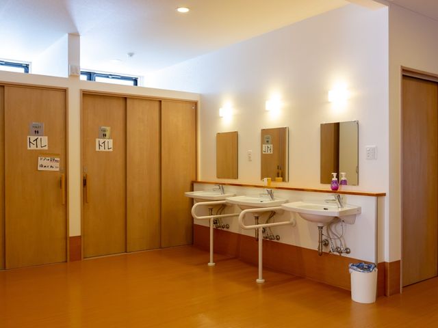清潔な洗面台とトイレの扉 洗面台 ゆとりのスペースを持つ清潔な手洗い場です。使いやすい高さに設計された水栓は、すべての利用者が快適にご使用いただけます。