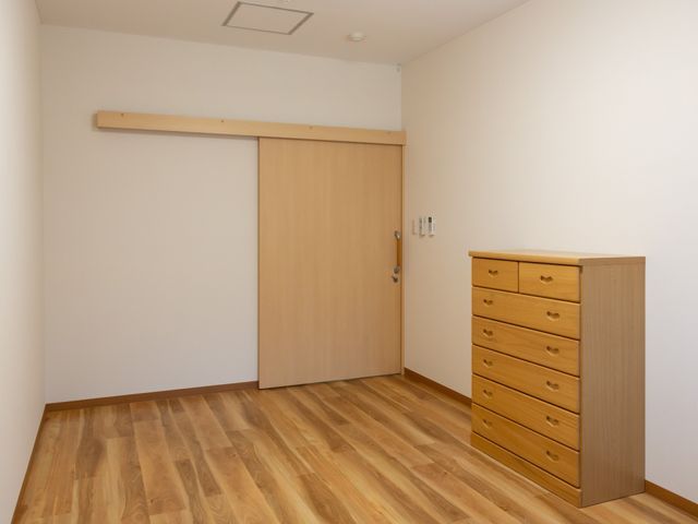清潔な居室の一角 居室 ゆとりある居室には木目調の家具が配置され、落ち着いた雰囲気が演出されています。利用者の安らぎの空間をご提供いたします。