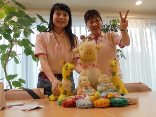 笑顔のスタッフ二人と手作り品