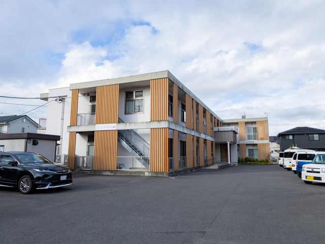 落ち着く外観の建物 外観 広い駐車スペースがあり、アクセスしやすい施設です。周辺には自然が広がっています。