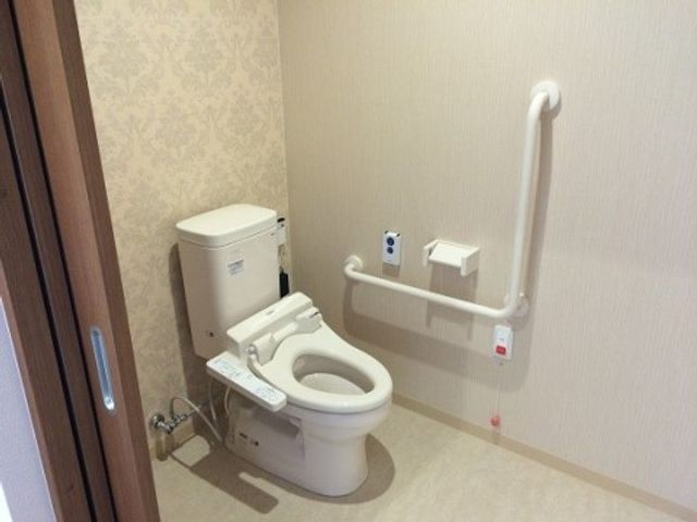 バリアフリートイレ トイレ 手すり付きの清潔なトイレで、利用者が安心して生活できます。安全と快適性を考慮した設計です。