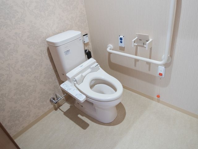 バリアフリー設計のトイレ トイレ 手すり付きで使いやすい洗練されたトイレです。安全かつ快適な利用が考慮されています。