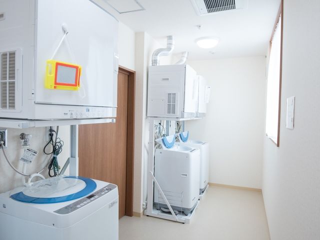 清潔な洗濯室 ランドリールーム 整理された洗濯機が並ぶ洗濯室です。いつでも清潔に保たれた環境で、快適な就労をサポートします。