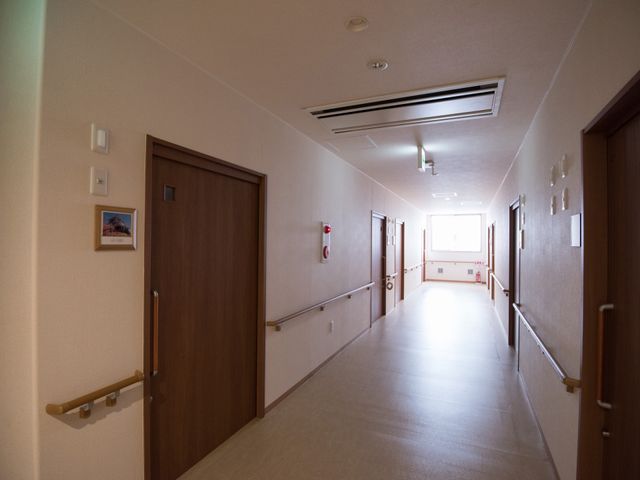 明るい廊下の風景 廊下 手すりが設置された廊下は明るく開放的で、居心地の良い環境を提供しています。手すりは歩行のサポートに役立ちます。