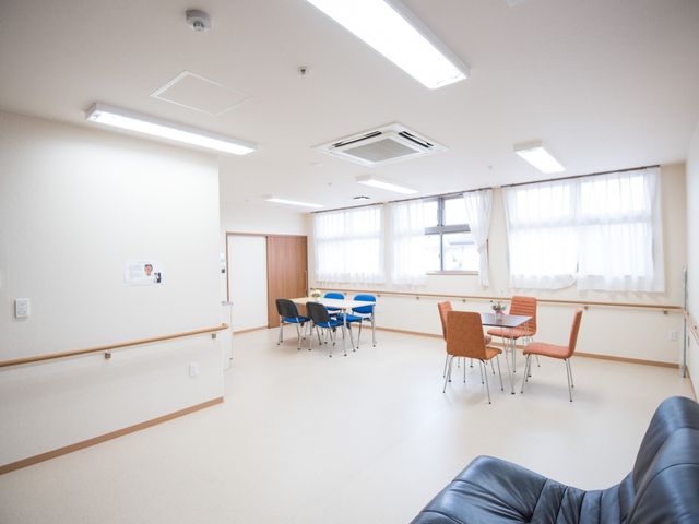 多目的室の明るい一角 リビング ゆったりとした多目的室では、テーブルを囲んで様々な活動が行えるようになっております。天窓からの自然光が心地よい空間を演出しています。