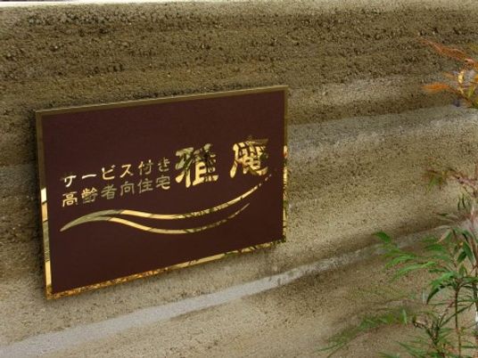 茶色い看板と緑の植物