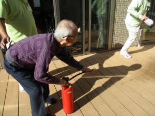 屋外で消火訓練をする人々