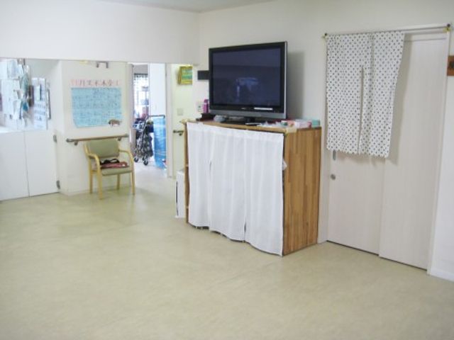 広々とした共有スペース 多目的スペース 広々としたスペースにはテレビも完備され、住まいの方々の憩いの場となっています。壁には掲示物もあり、情報共有が行える環境です。