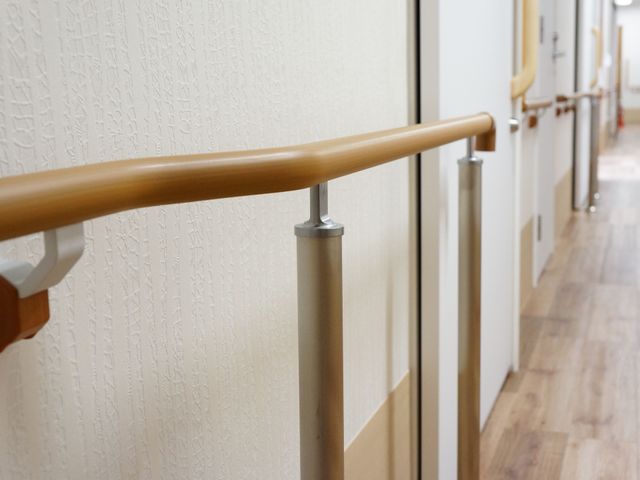 廊下の手すりと柔らかい照明 手すり 手すりが設置されたきれいな廊下です。歩行時の安全を支える配慮が行き届いています。