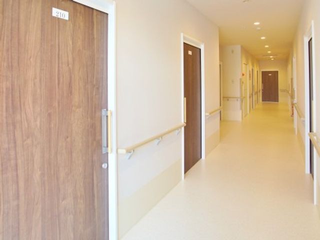 明るく清潔な廊下 廊下 床には滑りにくい材質を使用し、安全で快適な移動をサポートしています。手すりも整備され、安心して歩行できる環境が整っております。
