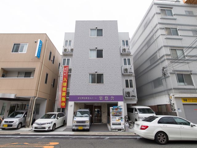都市部の建物正面 外観 現代的なデザインの明るい建物で、街並みに溶け込むおしゃれな外観です。通りからのアクセスも良好で、都会での就業に適しています。
