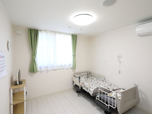清潔な洋室の居室 居室 落ち着いた色合いで統一された居室は、ゆったりとした時間を過ごせる環境を提供しています。清潔感のある空間は、新たな職場として魅力的です。