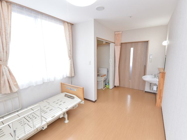 快適な居室の様子 居室 広々とした明るい居室です。手すり付きのベッドや洗面台も備え、快適な生活空間が確保されています。