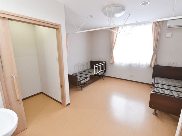居室の明るい空間 居室 明るく広々としたこの部屋は、プライバシーを重視される方にも快適な空間を提供します。機能的なベッドと広めの窓が日々のくつろぎに一役買っています。