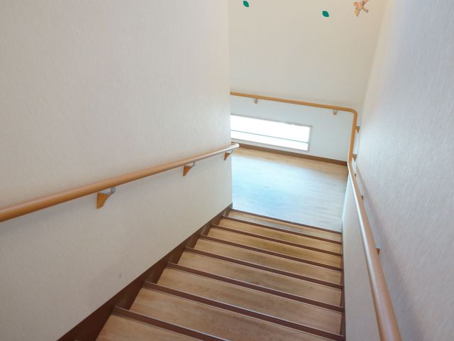 明るい手摺り付き階段 階段 手すりを設けた階段は安全かつ使いやすい設計で、日々の移動も安心です。明るく清潔感のある通路が印象的です。