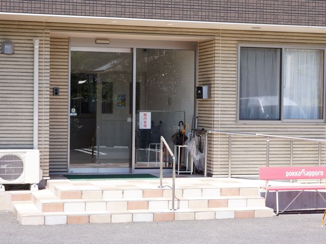 エントランスの外観 入口 スロープ付きでバリアフリー設計されたエントランスです。利用者の方々が容易に出入りできる環境が整っております。