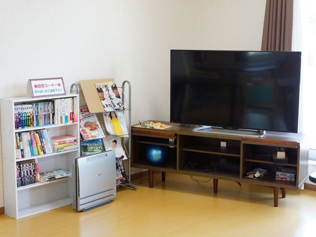 快適なリビングエリア 共有スペース ゆったりとしたリビングで、多種多様な書籍や雑誌を手に取りながらのんびり過ごすことができます。大型テレビがあり、皆様で映画鑑賞などをお楽しみいただける空間です。