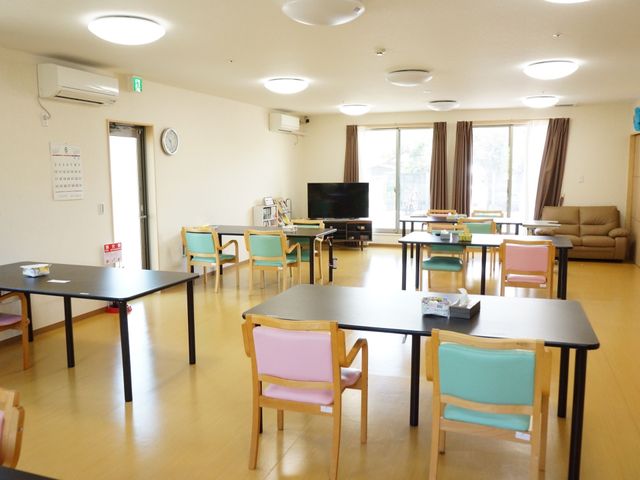 広々とした共有ラウンジ 共有スペース ゆったりと配置された椅子とテーブルが、来訪者のくつろぎのひとときを支えています。大型テレビが備えられたこのスペースは、リラックスした時間を過ごせる場所です。