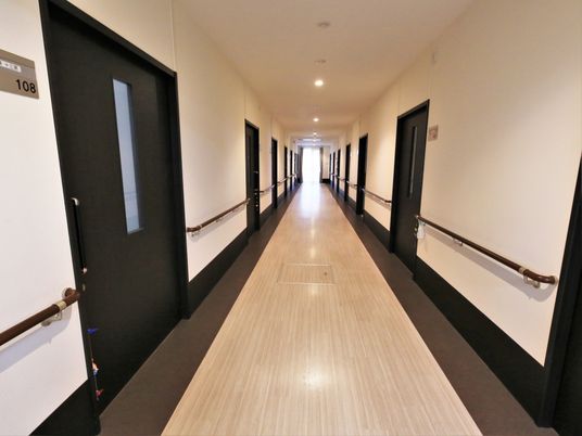 共用廊下の両側の壁には、腰の高さに手すりを設置している。入居者様はそれを伝いながら安全に通行することができる。