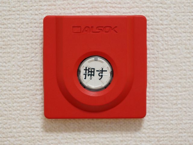 赤い非常ベルのクローズアップ 緊急時ボタン 手の届きやすい場所に設置された赤い非常ベルは、緊急時に安心です。