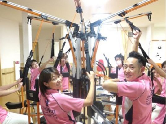 リハビリ装置と笑顔のスタッフ