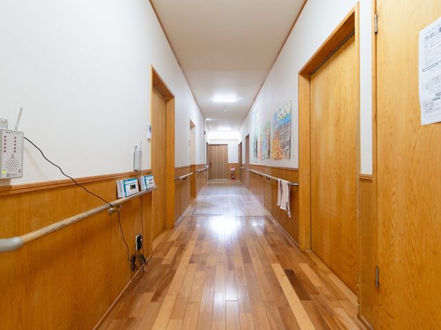 清潔感のある廊下 廊下 手すりが備えられた明るく清潔な通路です。壁に飾られたアートが心地よい雰囲気を醸し出しており、訪れる方々に安らぎを提供しています。
