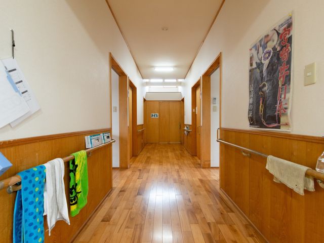 廊下の風景 廊下 手すりが設置された明るく清潔感のある廊下です。壁に掲げられた掲示物には、利用者の交流を促すイベント情報があります。