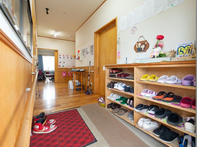 木目調廊下の靴棚と手すり 玄関 温かみのある木目調の廊下には、手すりと靴棚が設置されており、安心して歩行できる設計になっています。