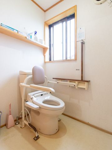 バリアフリー設計のトイレ トイレ 安全に配慮された広々としたトイレ空間です。手すりや高齢者向けの機能を備え、利用しやすい環境が整っています。