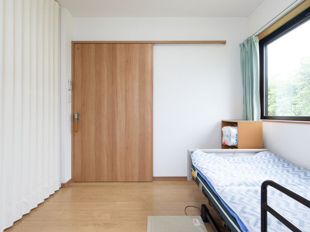 ベッドと窓のある居室 居室 ゆったりとした床の間を備えた居室です。窓から自然光が差し込み、穏やかな時間をお過ごしいただけます。