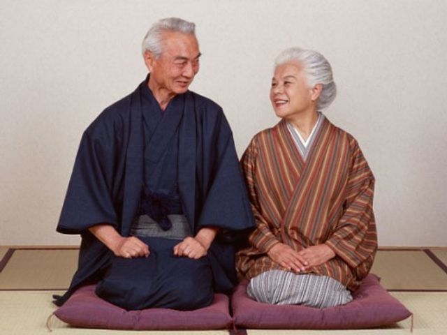 和服を着た笑顔のご夫婦 生活 伝統的な和室でくつろぐ機会は、ご利用者様に落ち着いた時間を提供します。ゆったりと会話を楽しむ姿が印象的です。